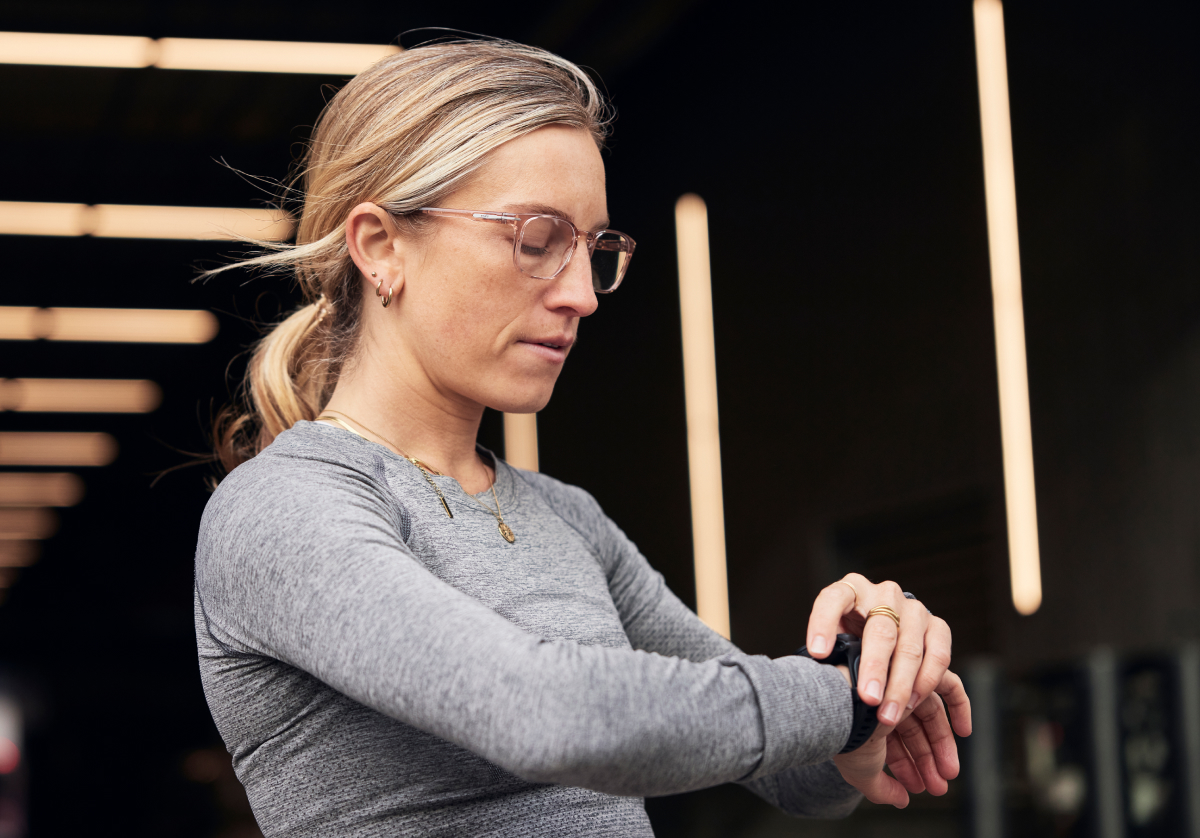 Woman checking her watch wearing rectangular, bourbon Cade eyeglasses