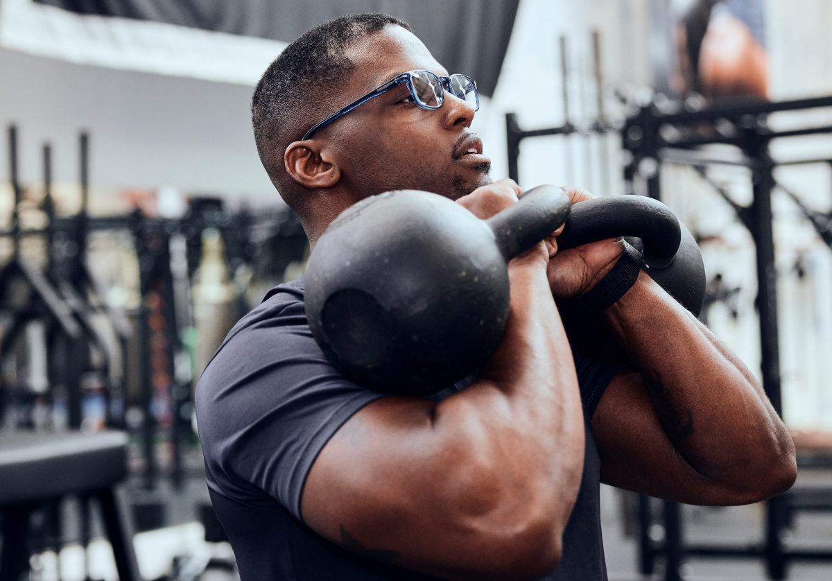Man holding kettlebells wearing rectangular, crystal slate Cade eyeglasses