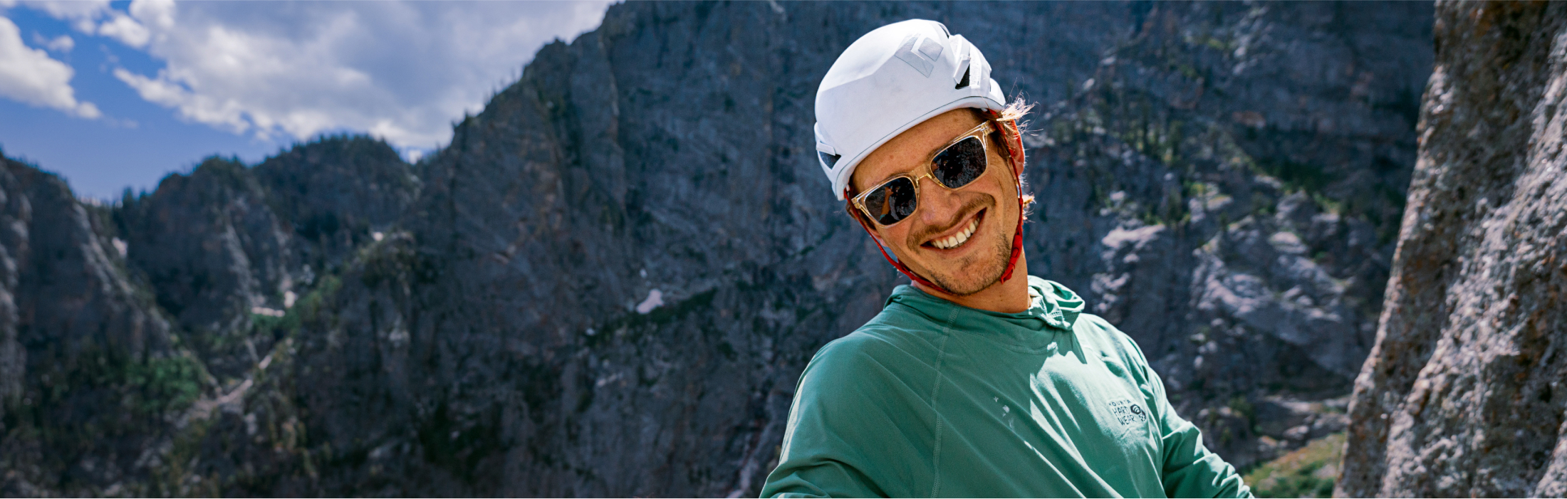 Man with helmet rock climbing wearing ROKA sunglasses