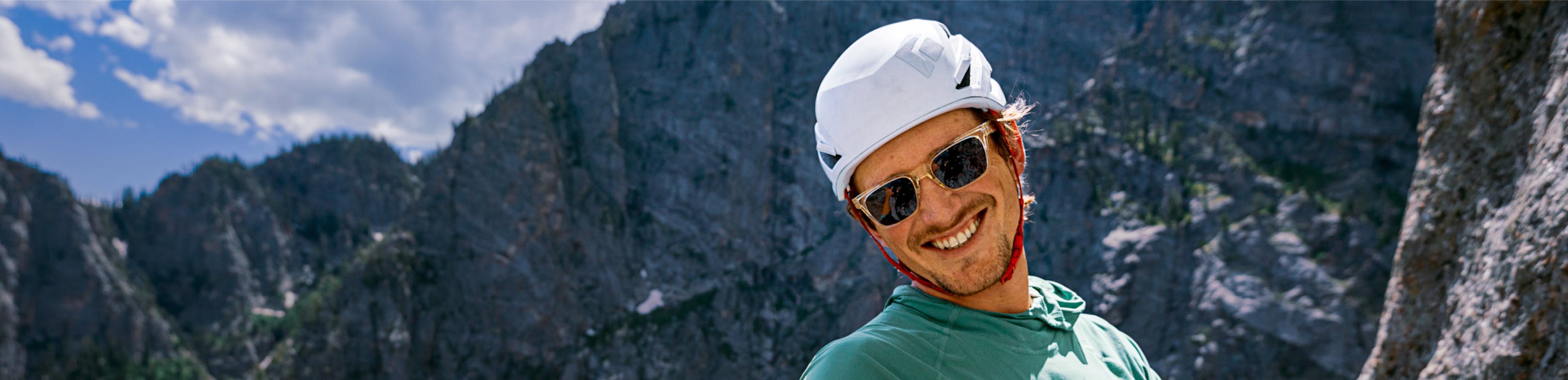 Man with helmet rock climbing wearing ROKA sunglasses