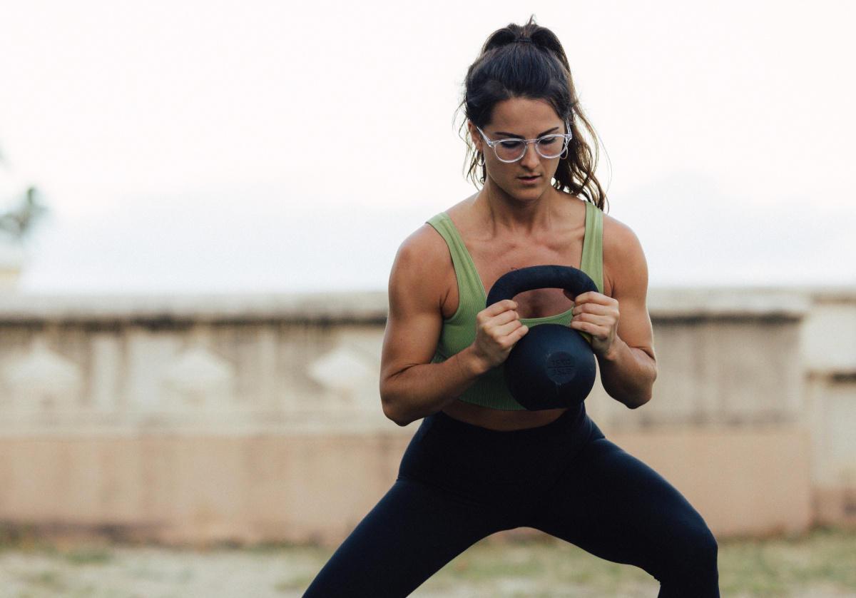 Woman training with kettlebell wearing round, clear frame Oslo eyeglasses