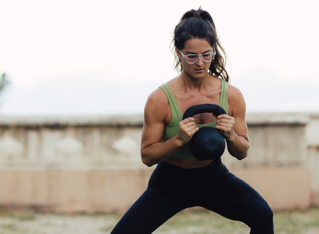 Woman training with kettlebell wearing round, clear frame Oslo eyeglasses
