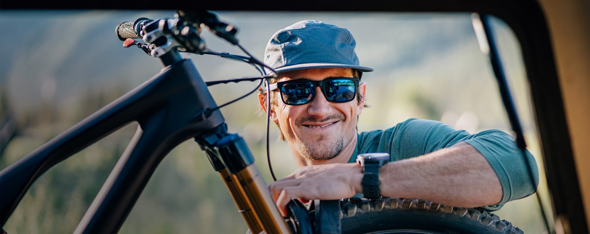 Man leaning on his bike wearing ROKA sunglasses