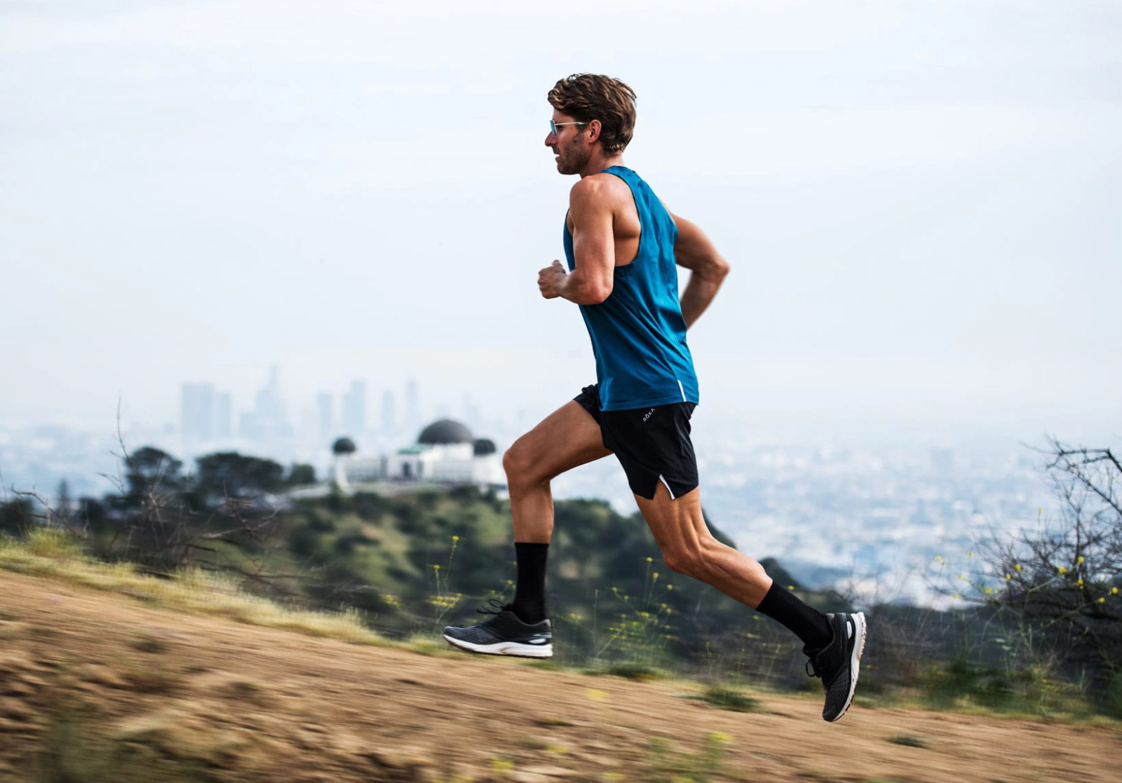 Man running uphill in blue tank top