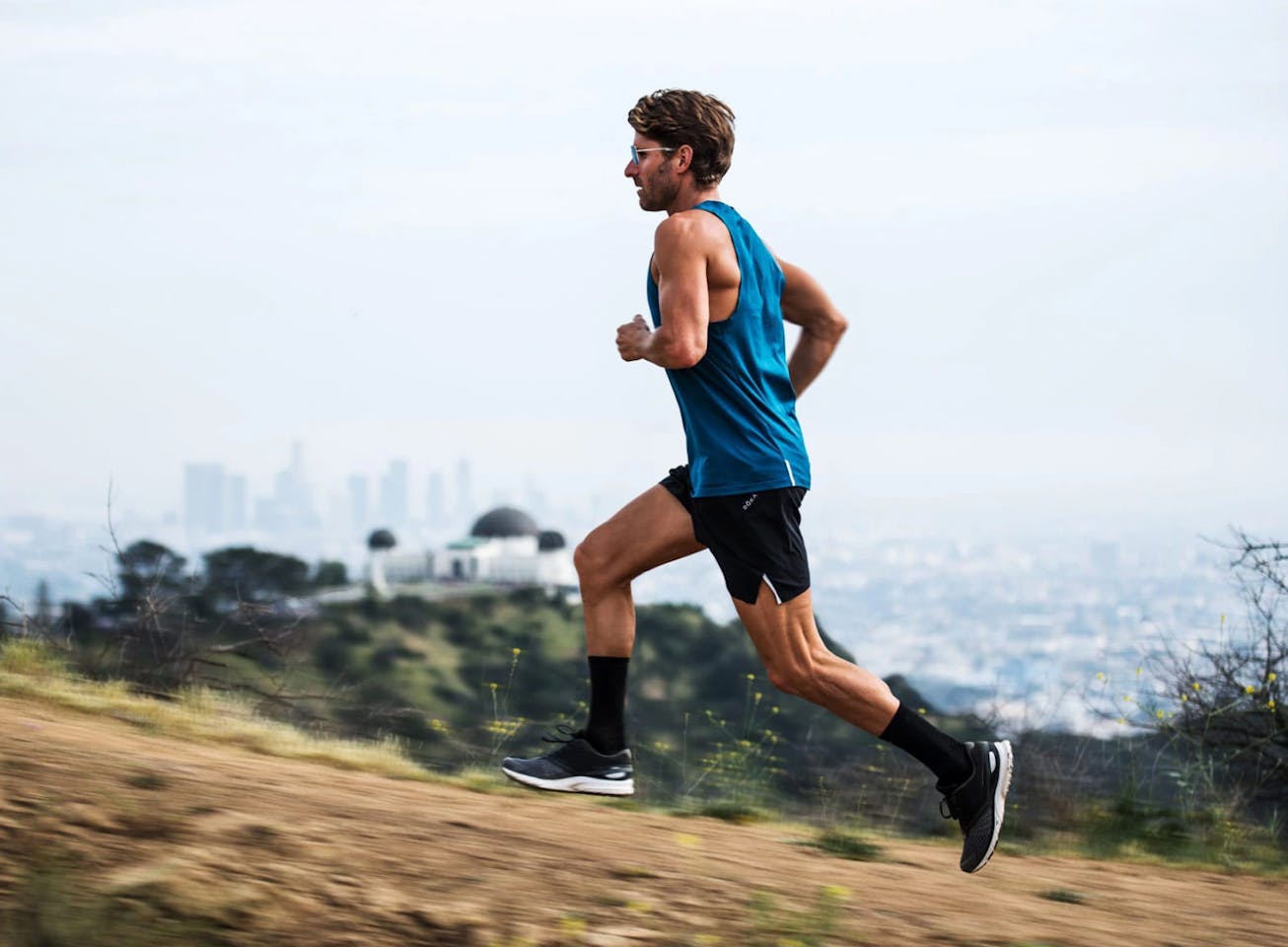 Man running uphill in blue tank top