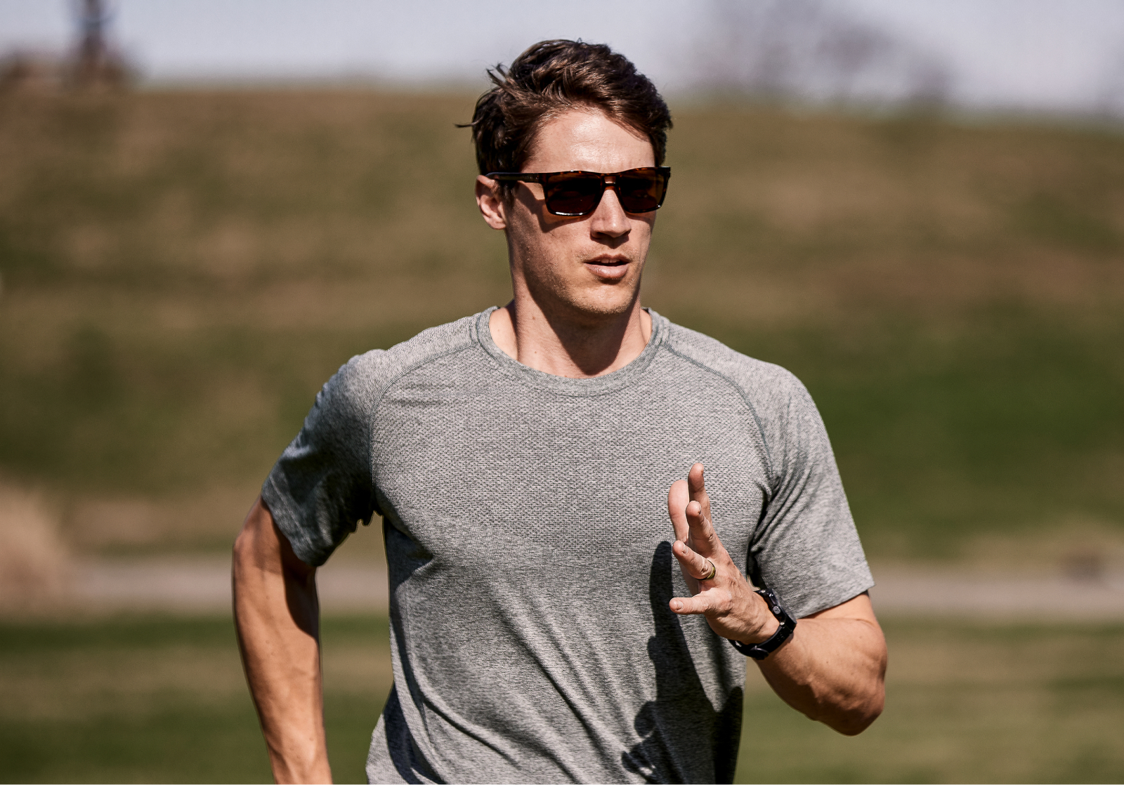 Man running outside wearing Kona sunglasses