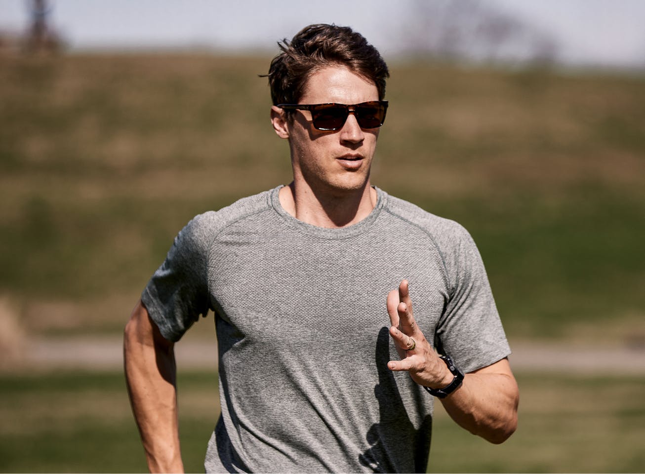 Man running outside wearing Kona sunglasses