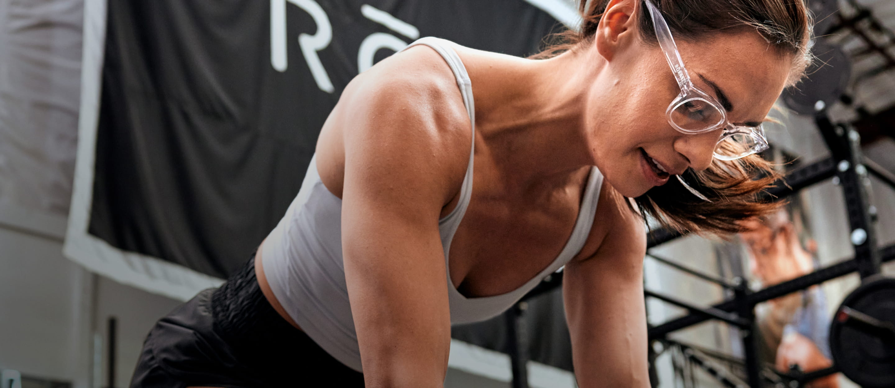 Woman looking down in gym wearing Hamilton eyeglasses