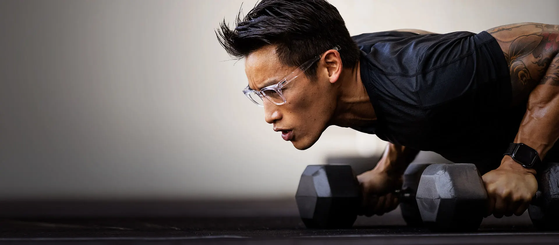 Man doing pushups with dumbells wearing Lockhart sunglasses