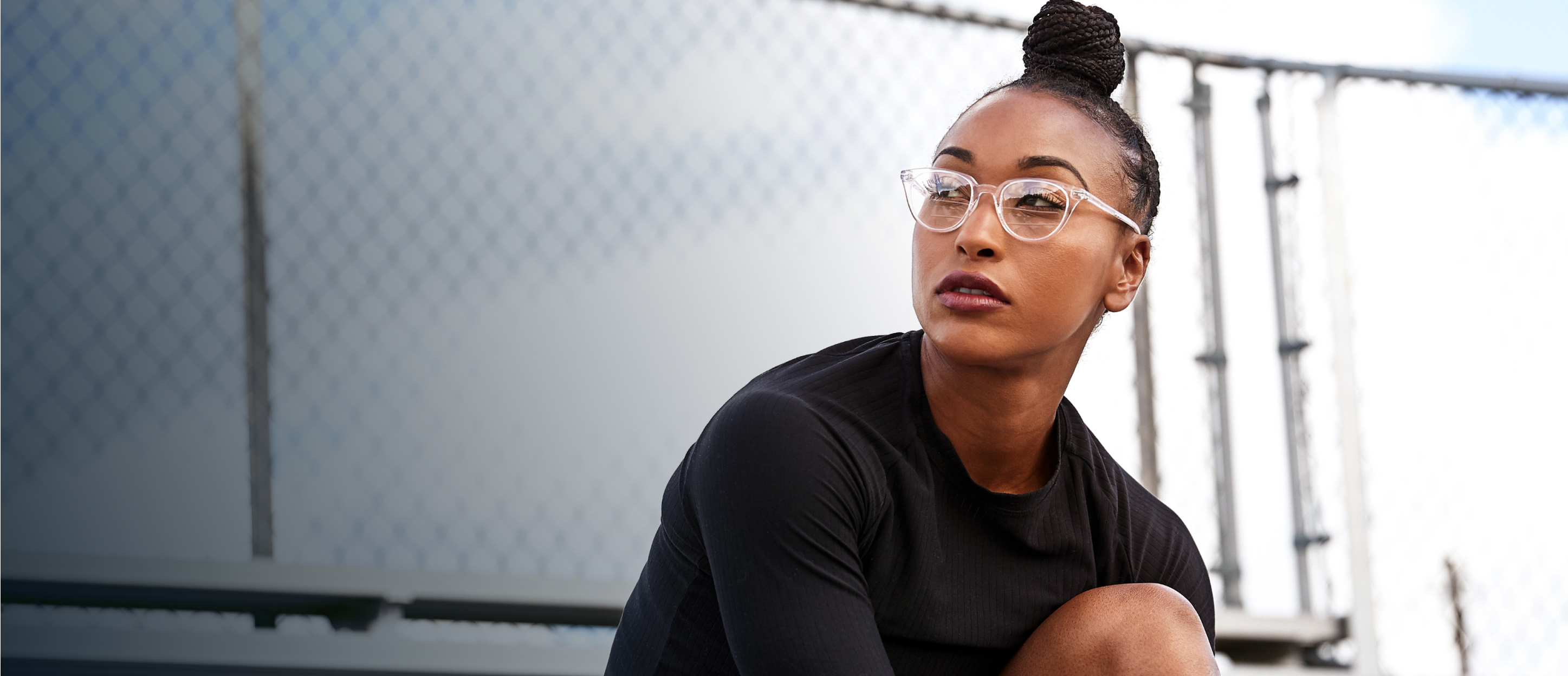 Woman sitting outside wearing cat eye shape, clear Lola eyeglasses
