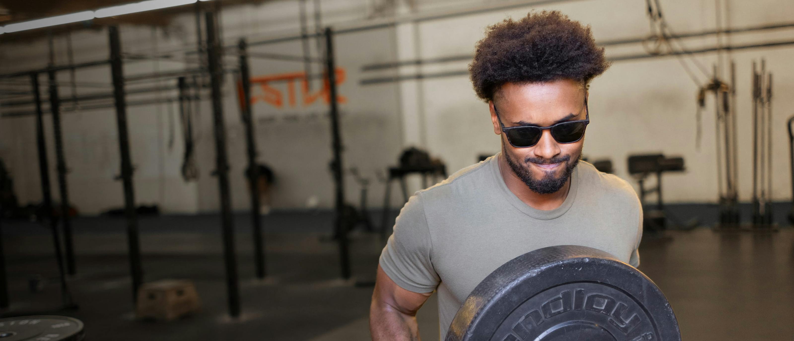 Man holding weight plate wearing Rory Sunglasses