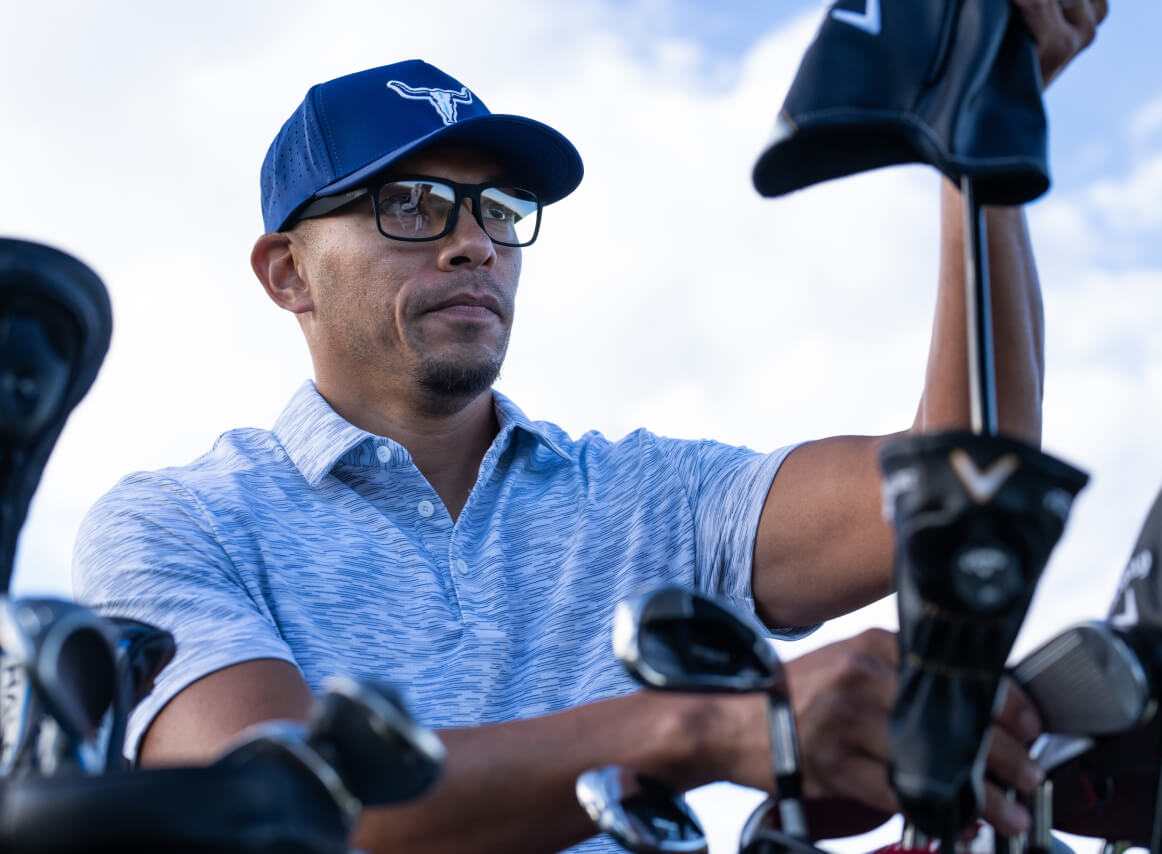 Man choosing golf club wearing Braker eyeglasses