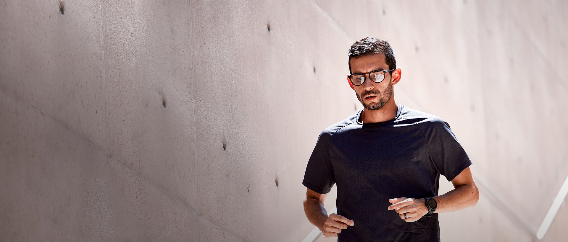 Man in black shirt jogging down stairs