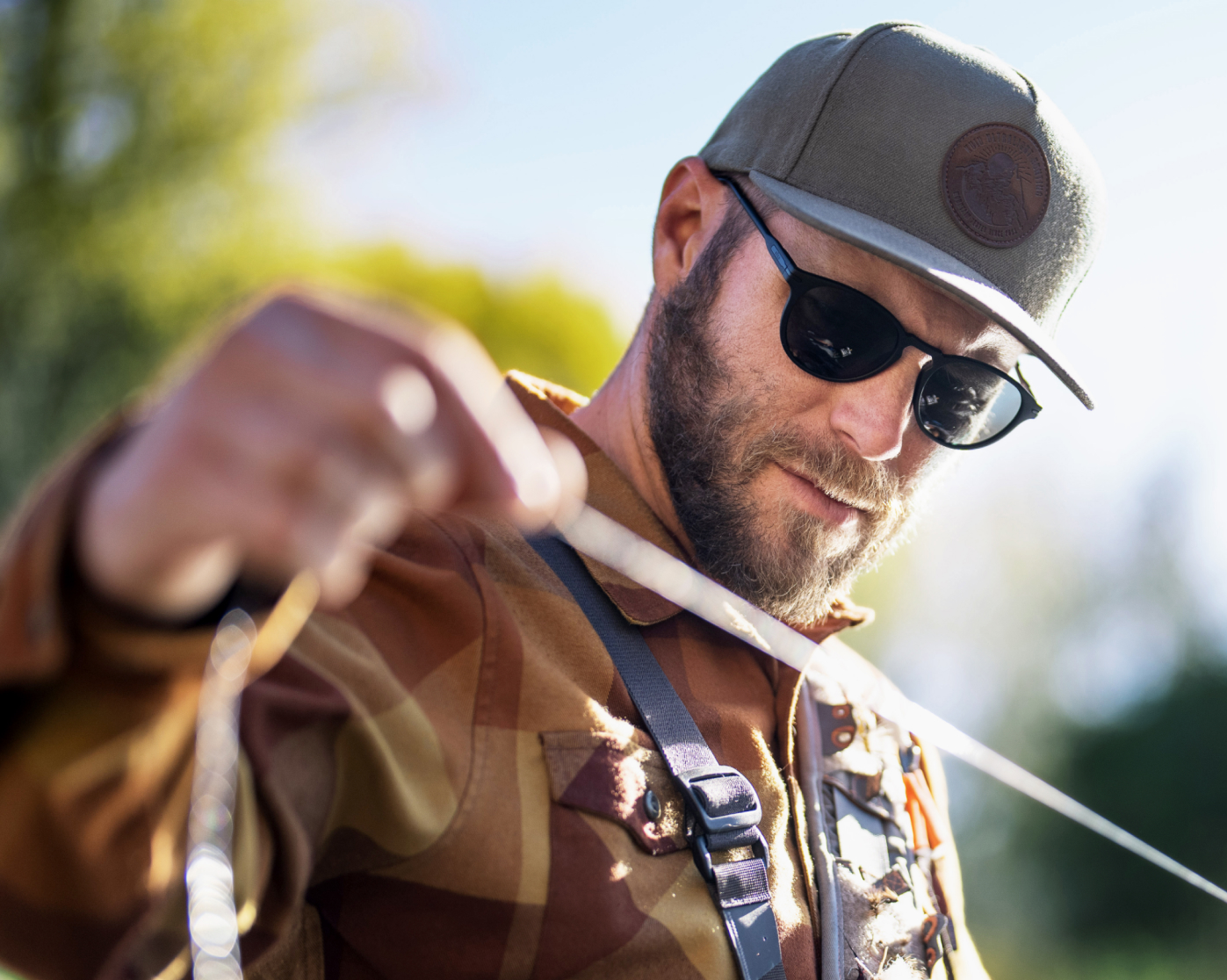 Fisherman holding line wearing Oslo sunglasses