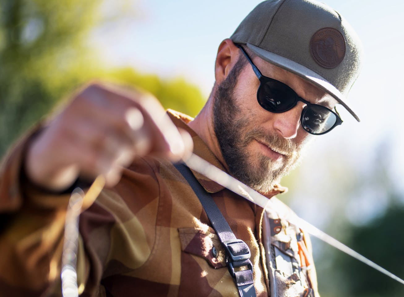 Fisherman holding line wearing Oslo sunglasses