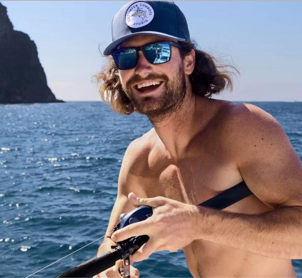 Man holding fishing rod wearing Glacier Mirrored Sunglasses
