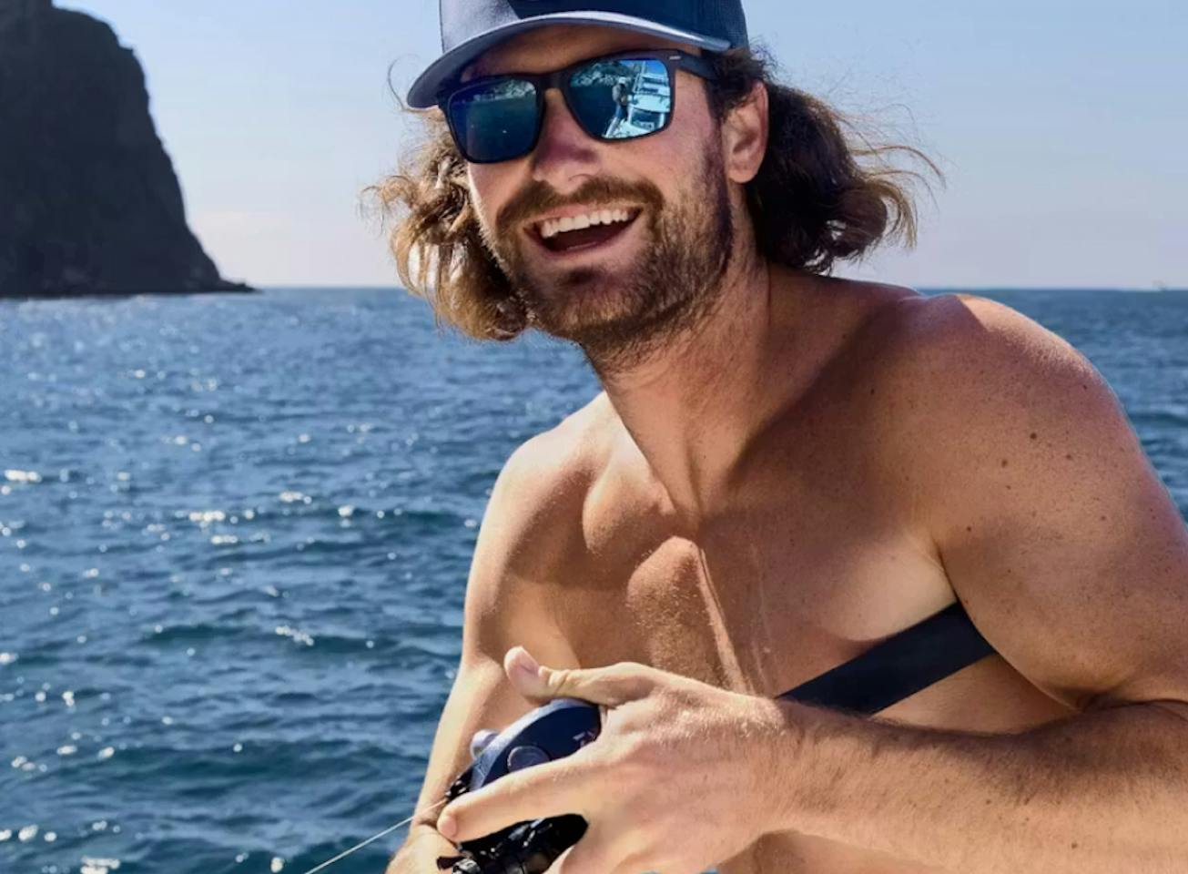 Man holding fishing rod wearing Glacier Mirrored Sunglasses