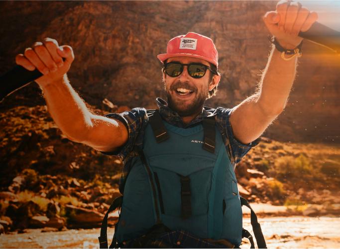 Man kayaking wearing red hat and ROKA sunglasses