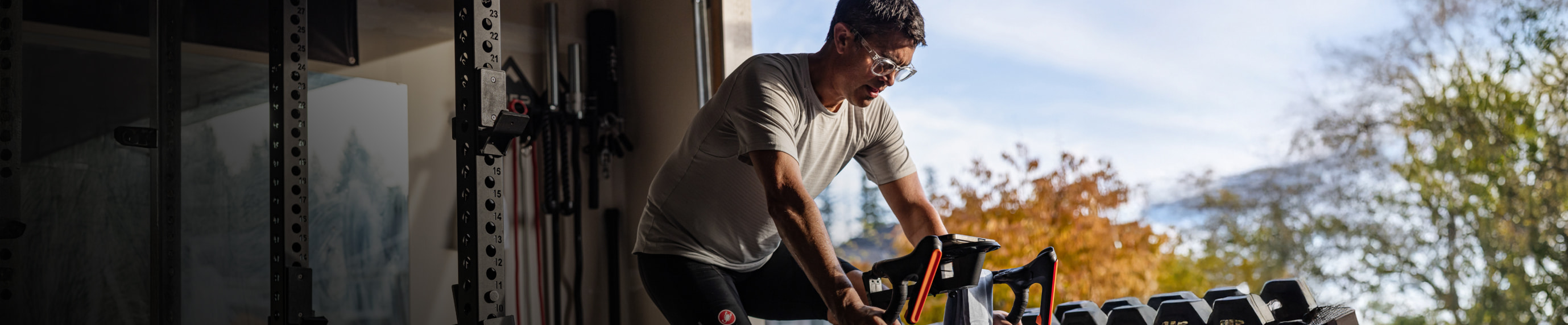Man riding trainer with reading glasses