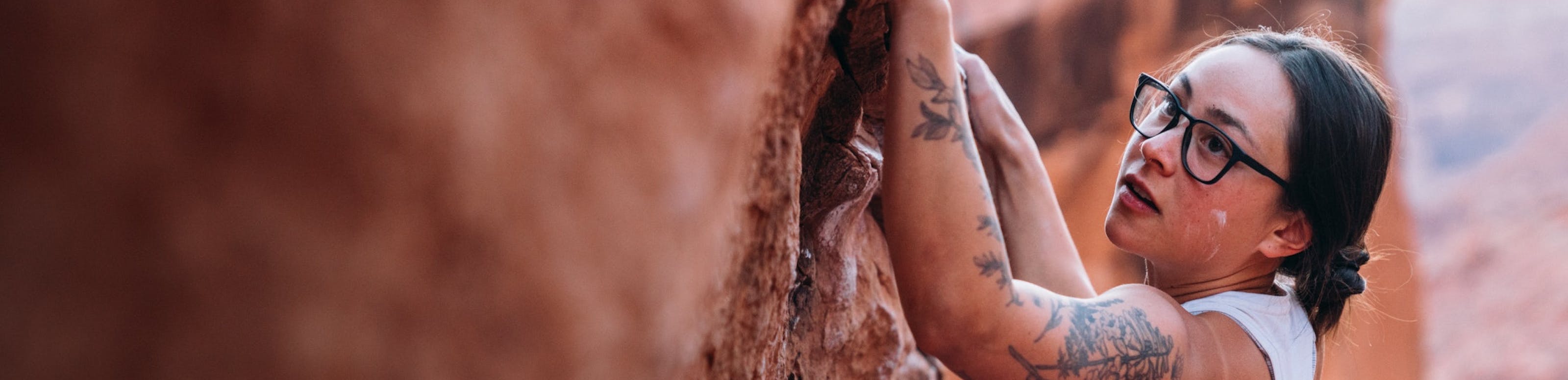 Women with tattoos bouldering in Rory eyeglasses