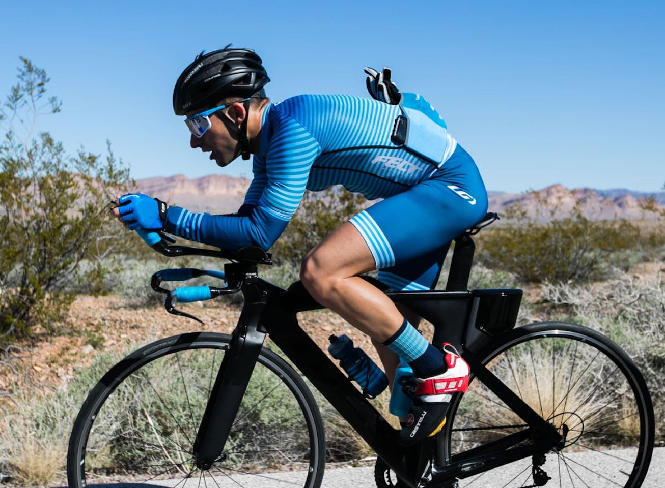 Man in blue cycling suit biking in the desert