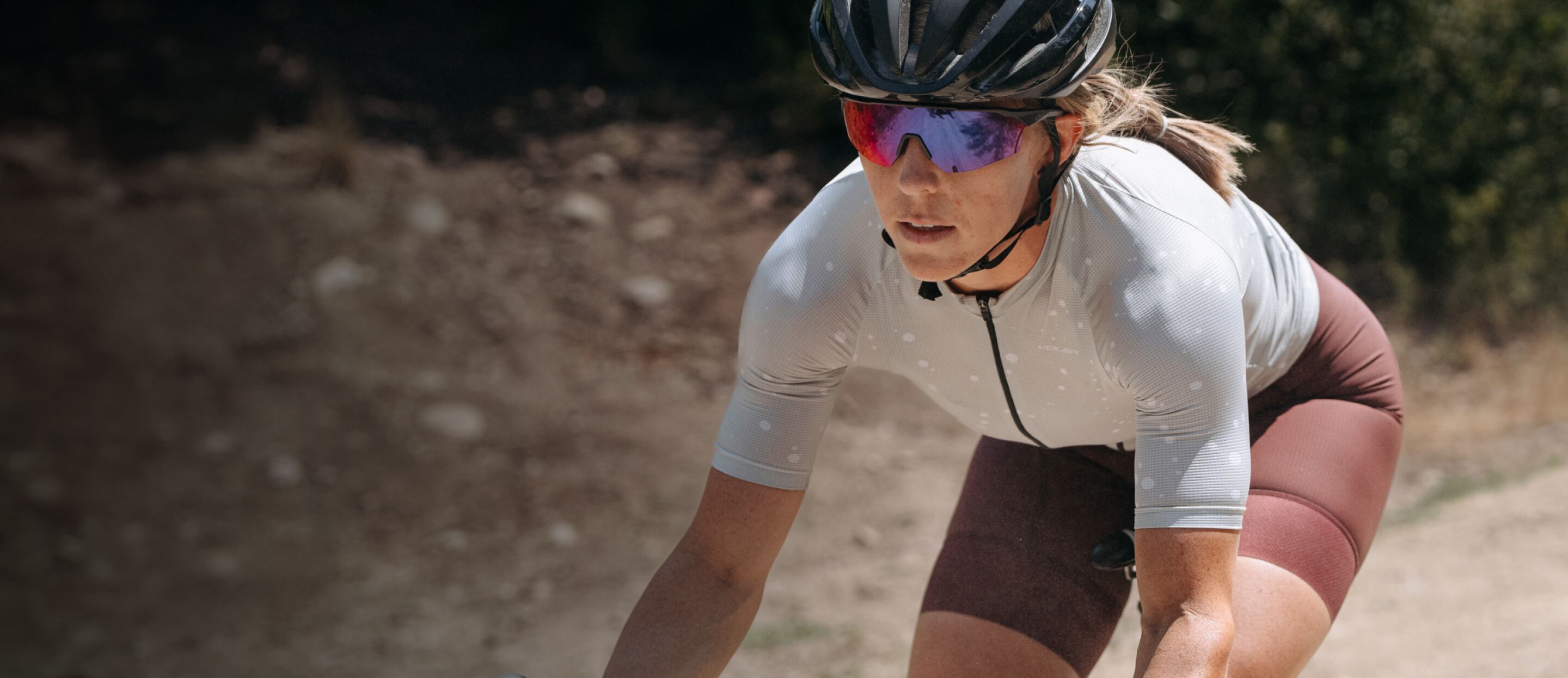 Woman cycling in white top and SR-1x sunglasses
