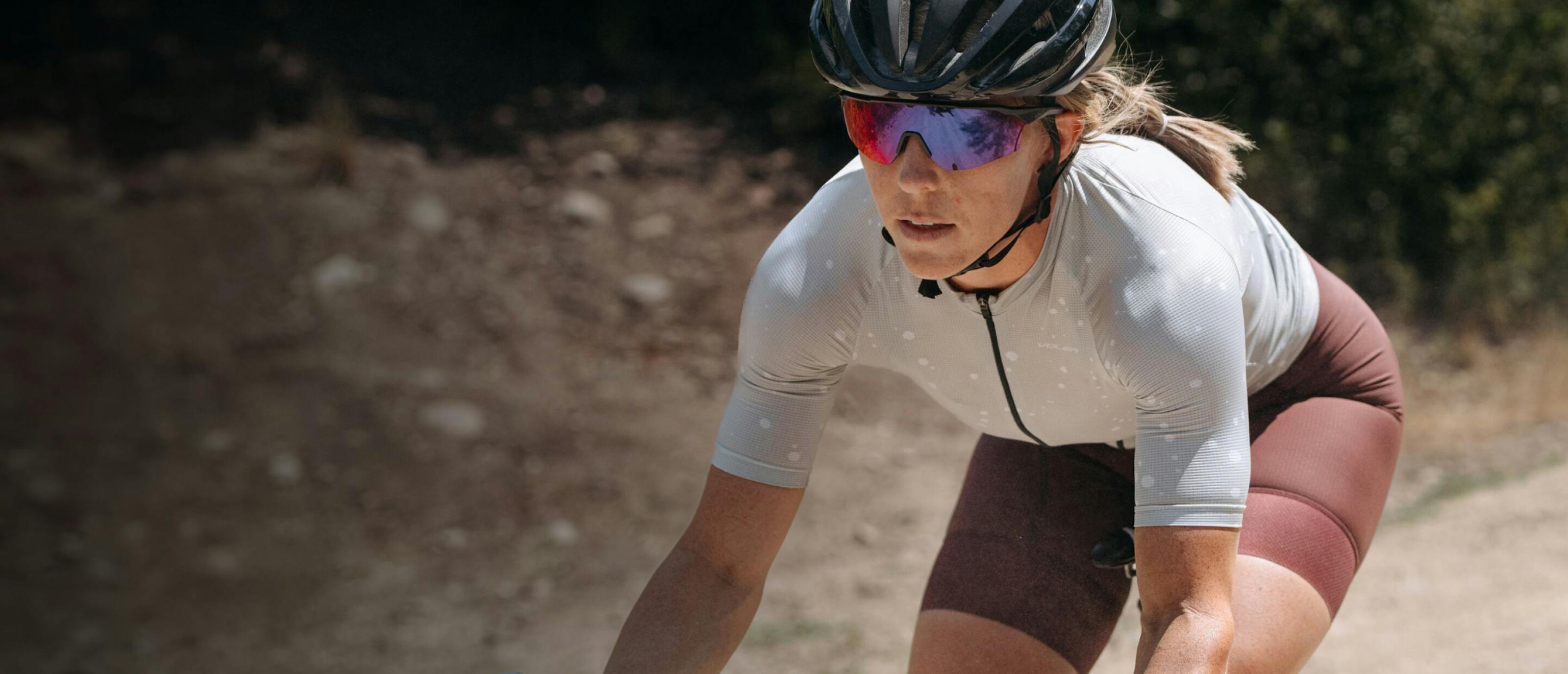 Woman cycling in white top and SR-1x sunglasses