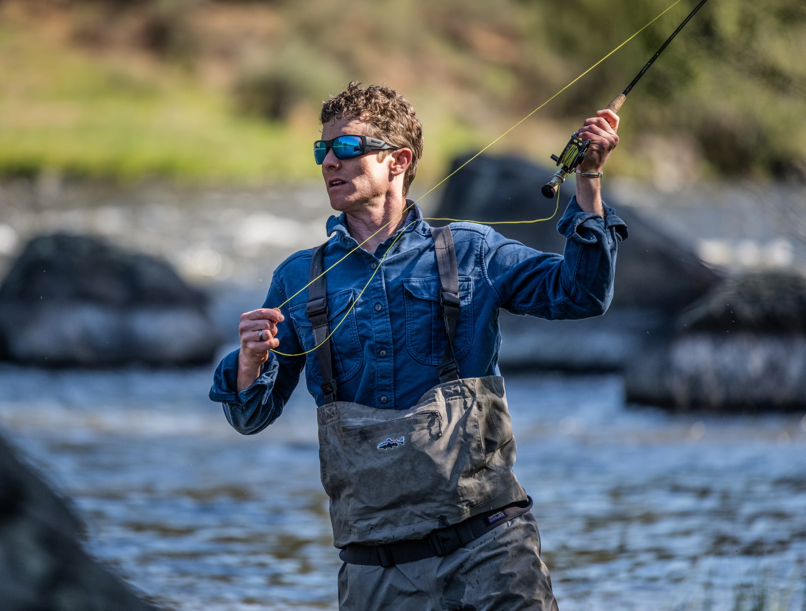 Man in river casting fishing rod