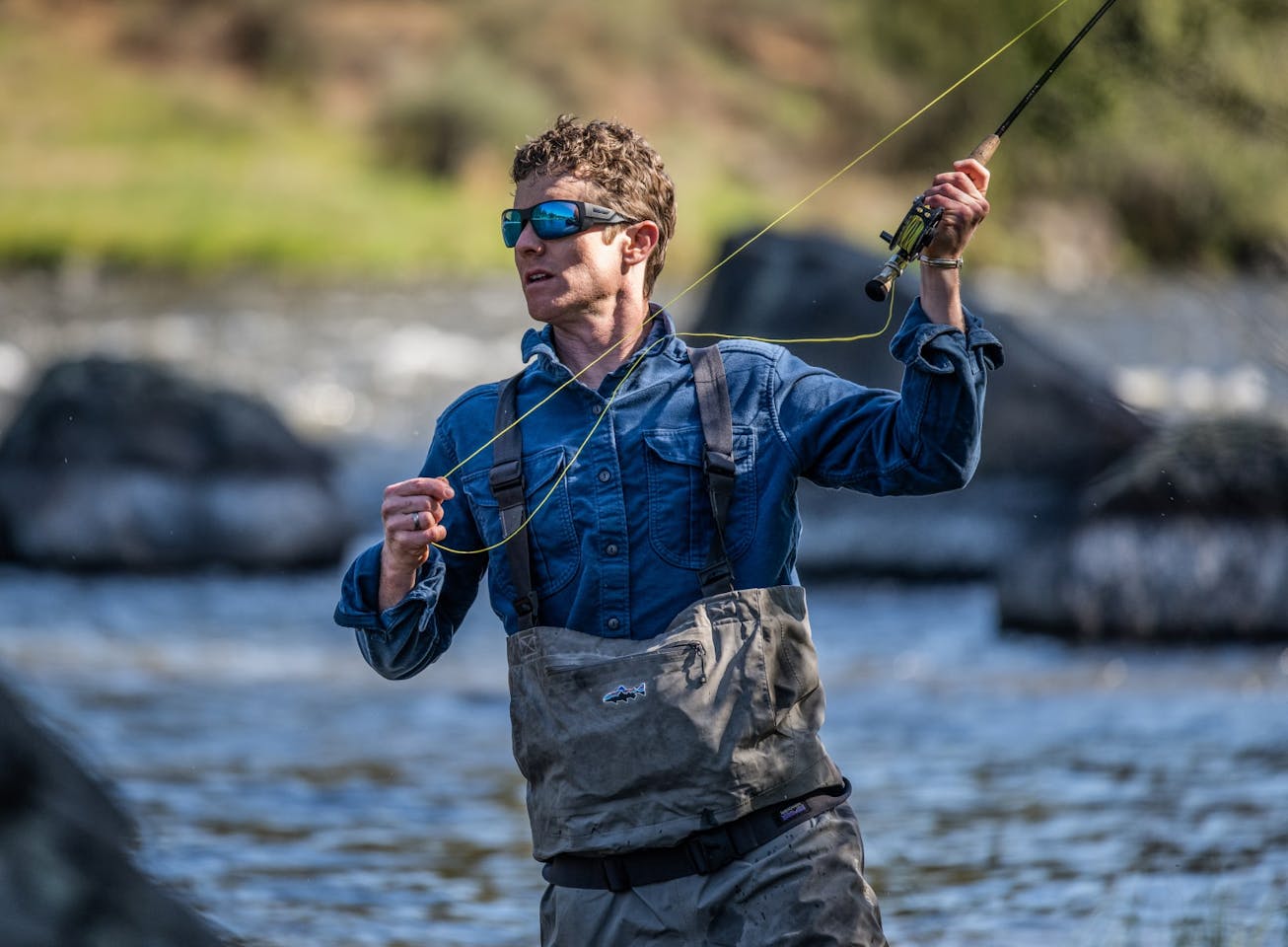 Man in river casting fishing rod
