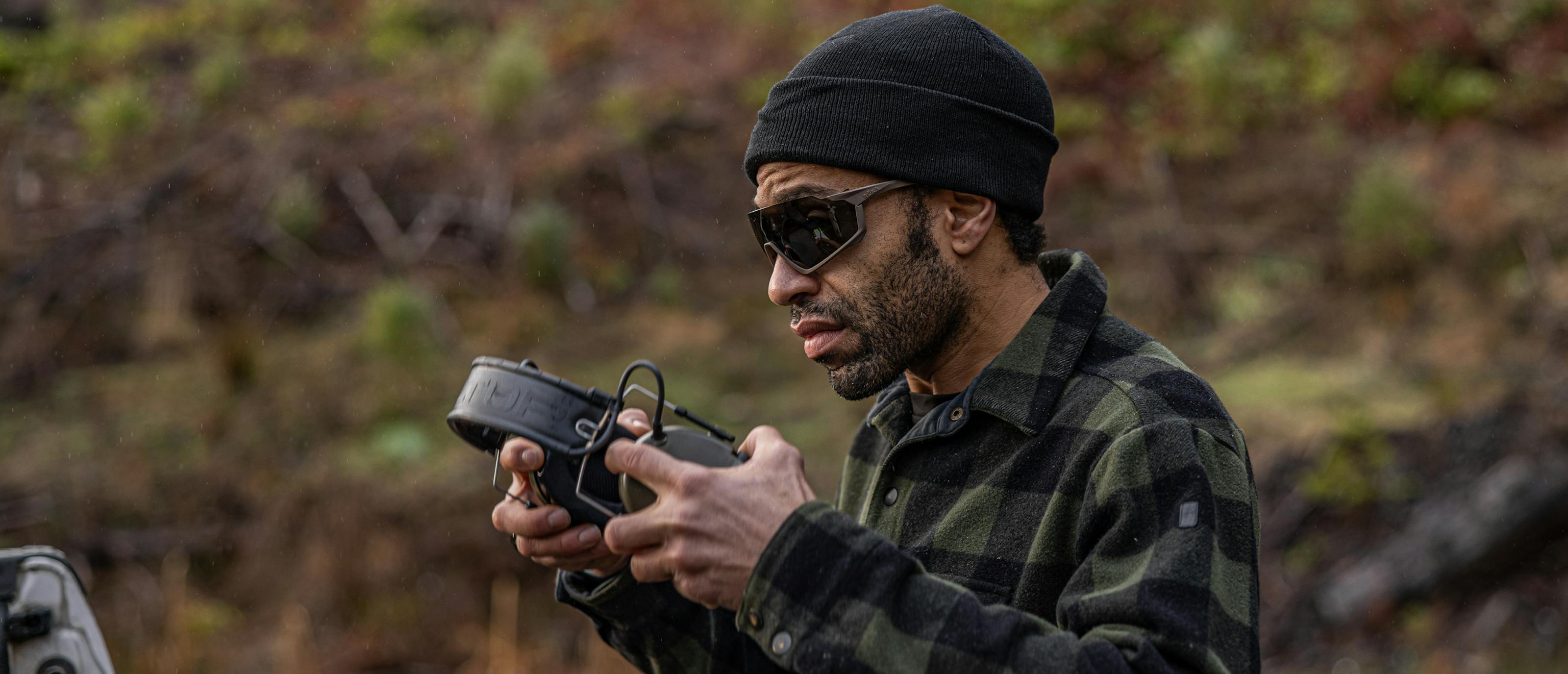 Man putting on earphones in GP-1xt sunglasses