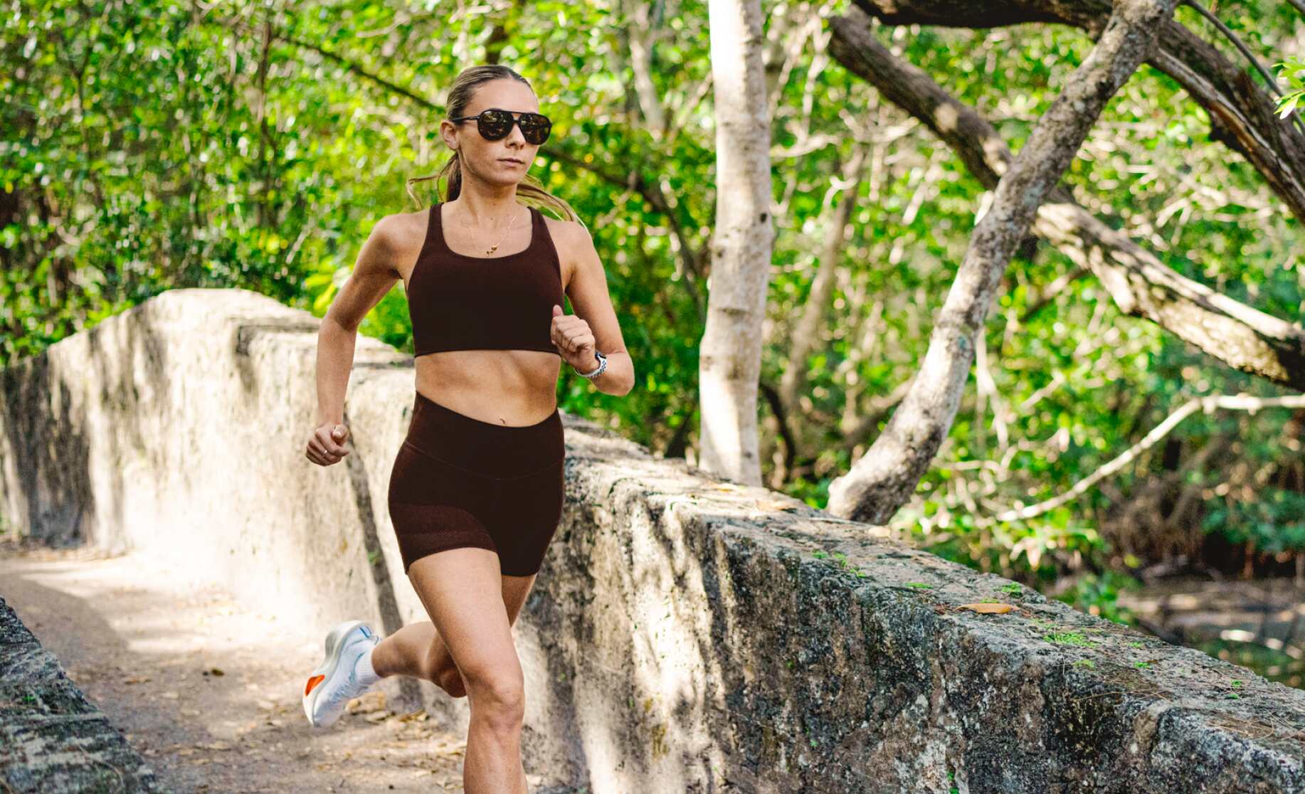 Woman running in woods in Havana sunglasses