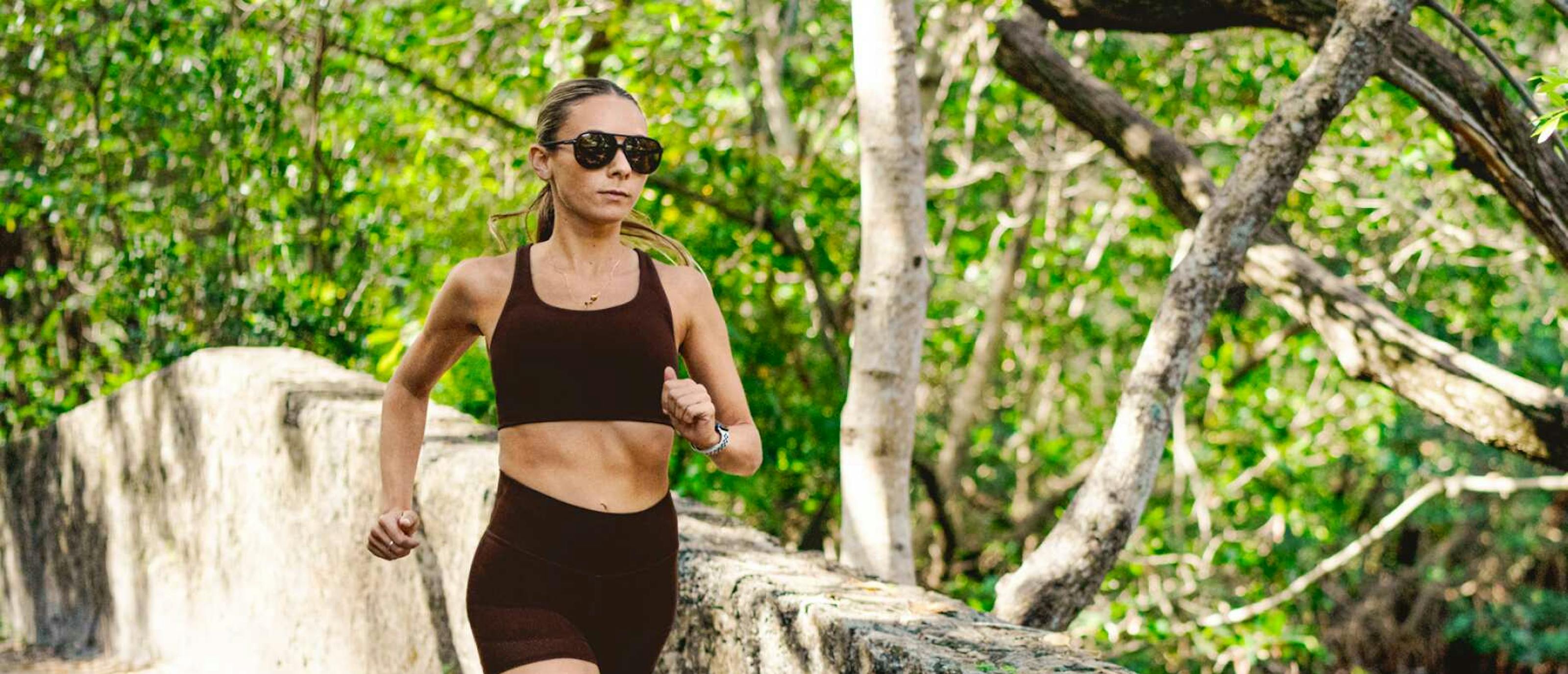 Woman running in woods in Havana sunglasses