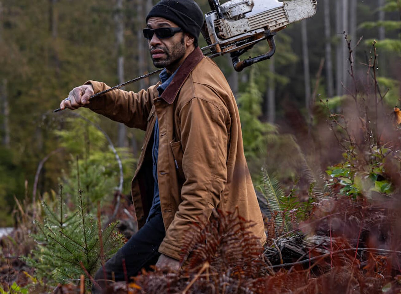 Man holding chainsaw in woods with AT-1 Sunglasses
