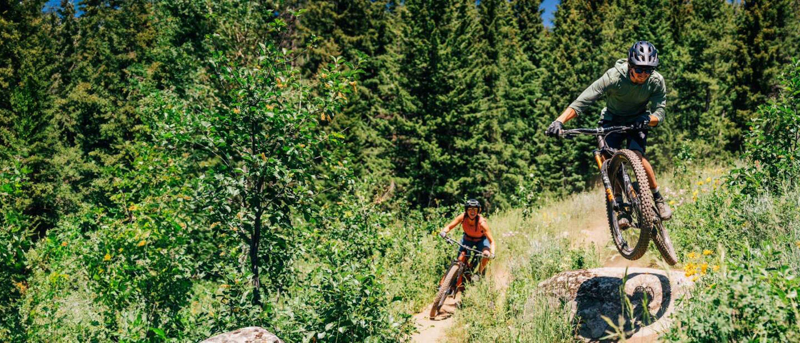 Man on mountain bike jumping a rock