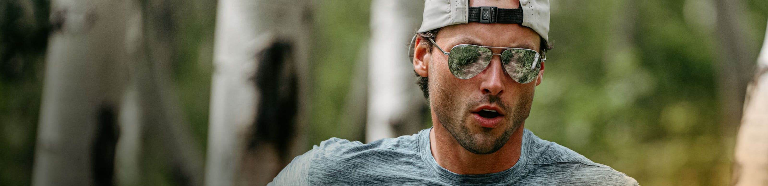 Man in woods running in ROKA sunglasses
