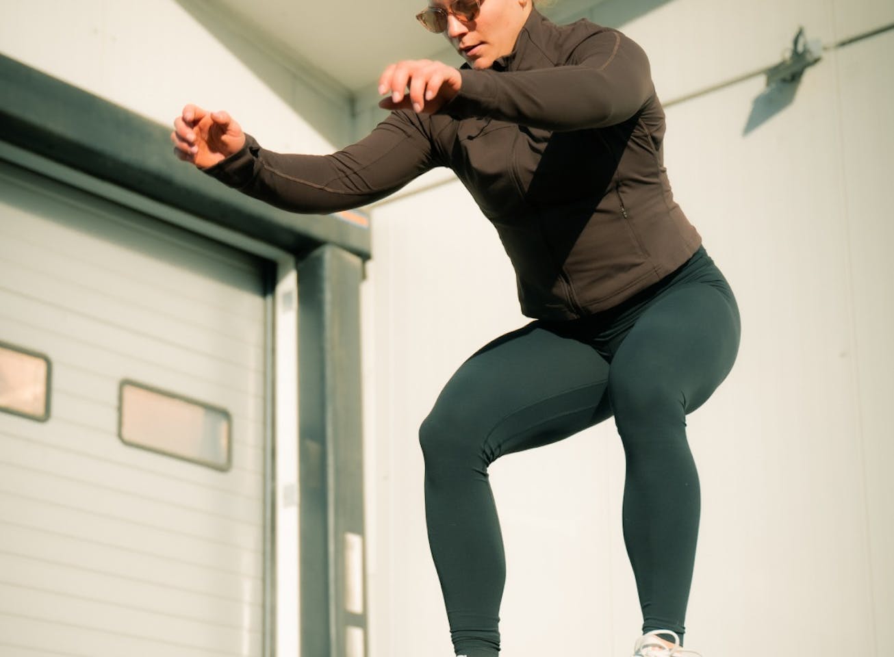 Woman box jumping in Lola sunglasses