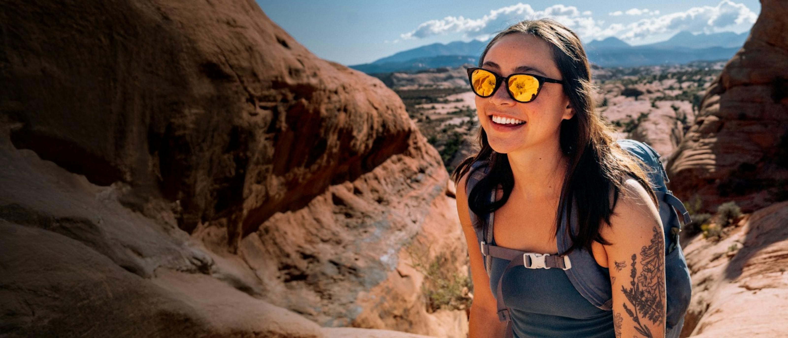 Woman smiling in canyon with gold Lola sunglasses