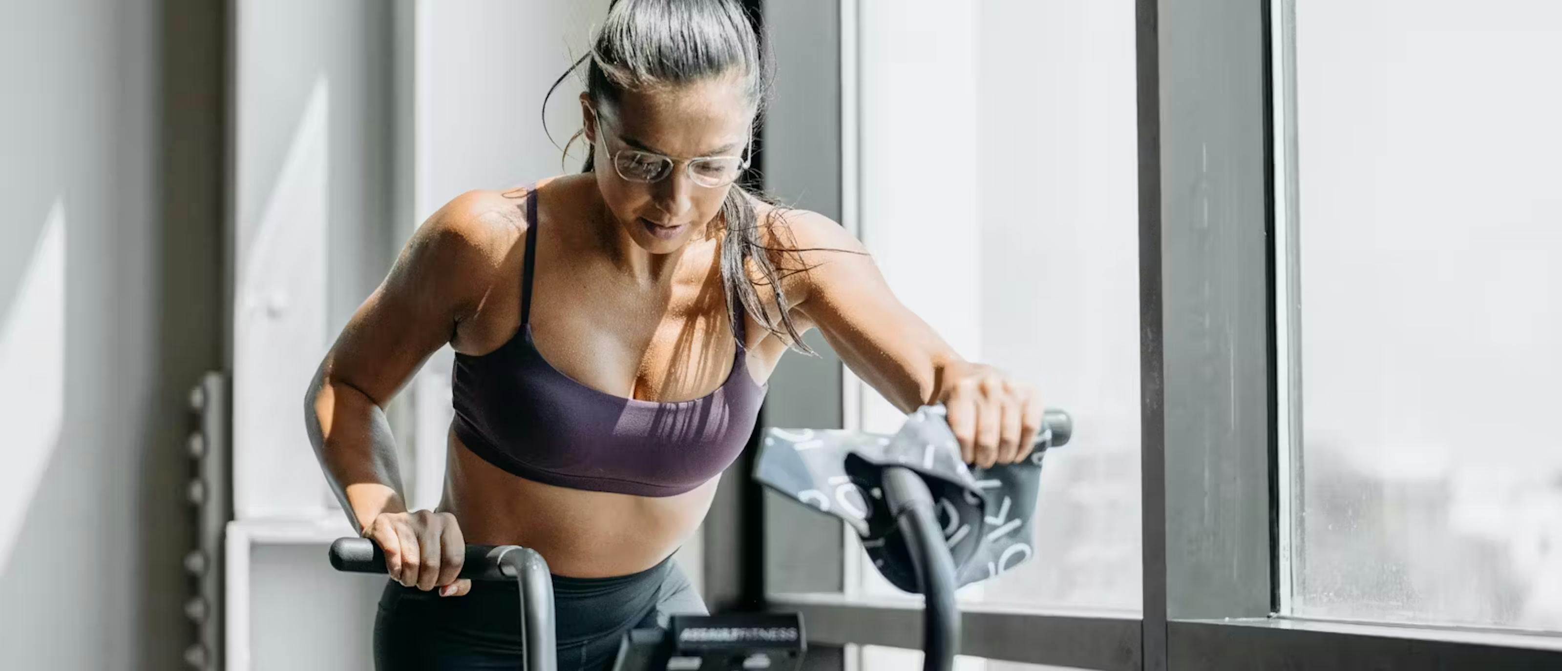 Woman on stationary bike wearing Rio eyeglasses