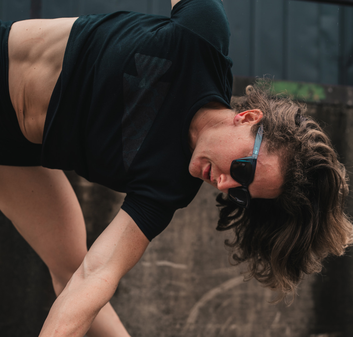 Woman bent over stretching wearing Marfa sunglasses