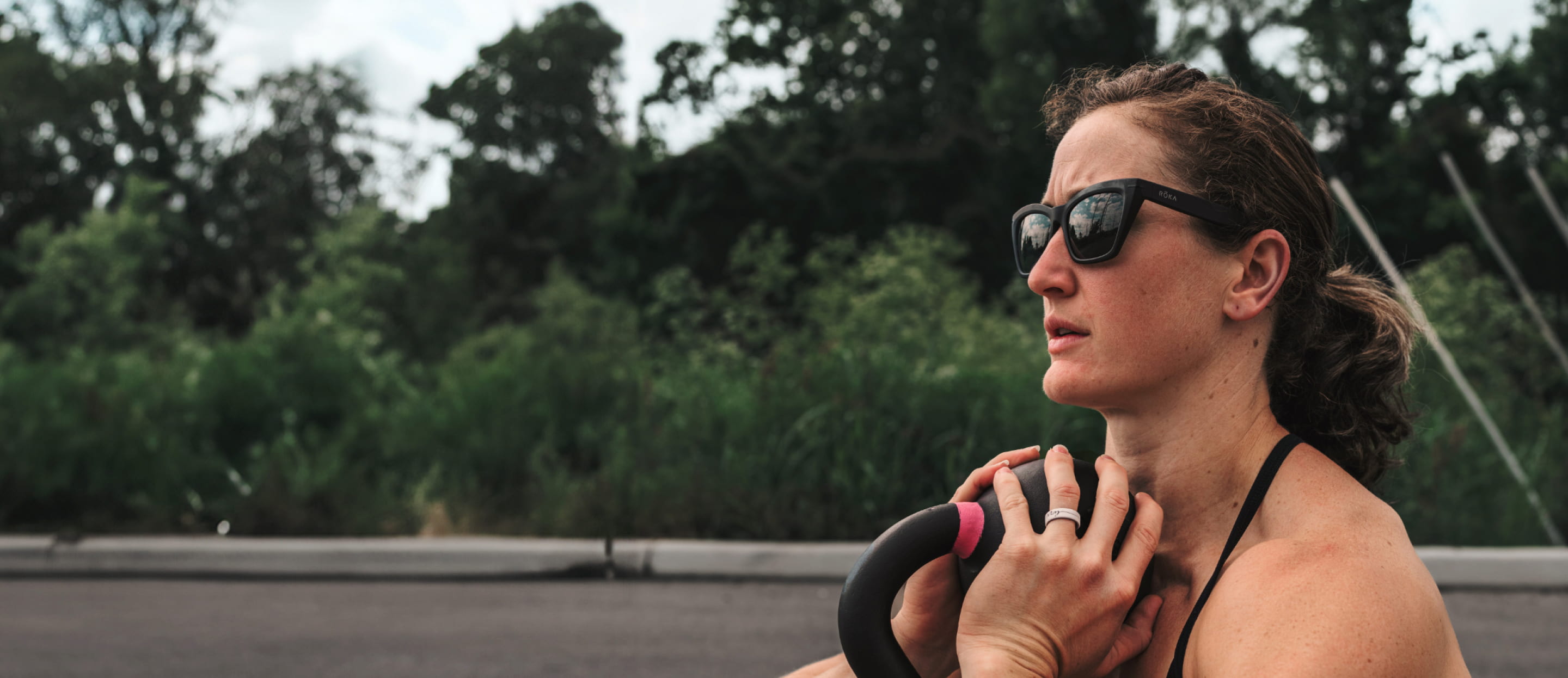 Woman holding kettlebell wearing Marfa sunglasses
