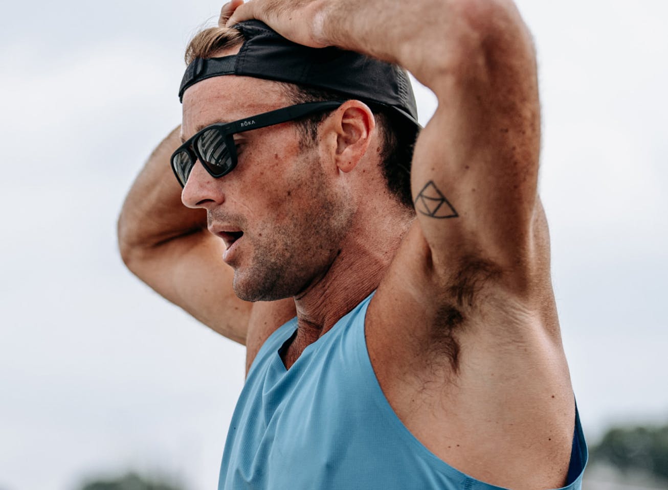 Man with hands over head in Estacado sunglasses