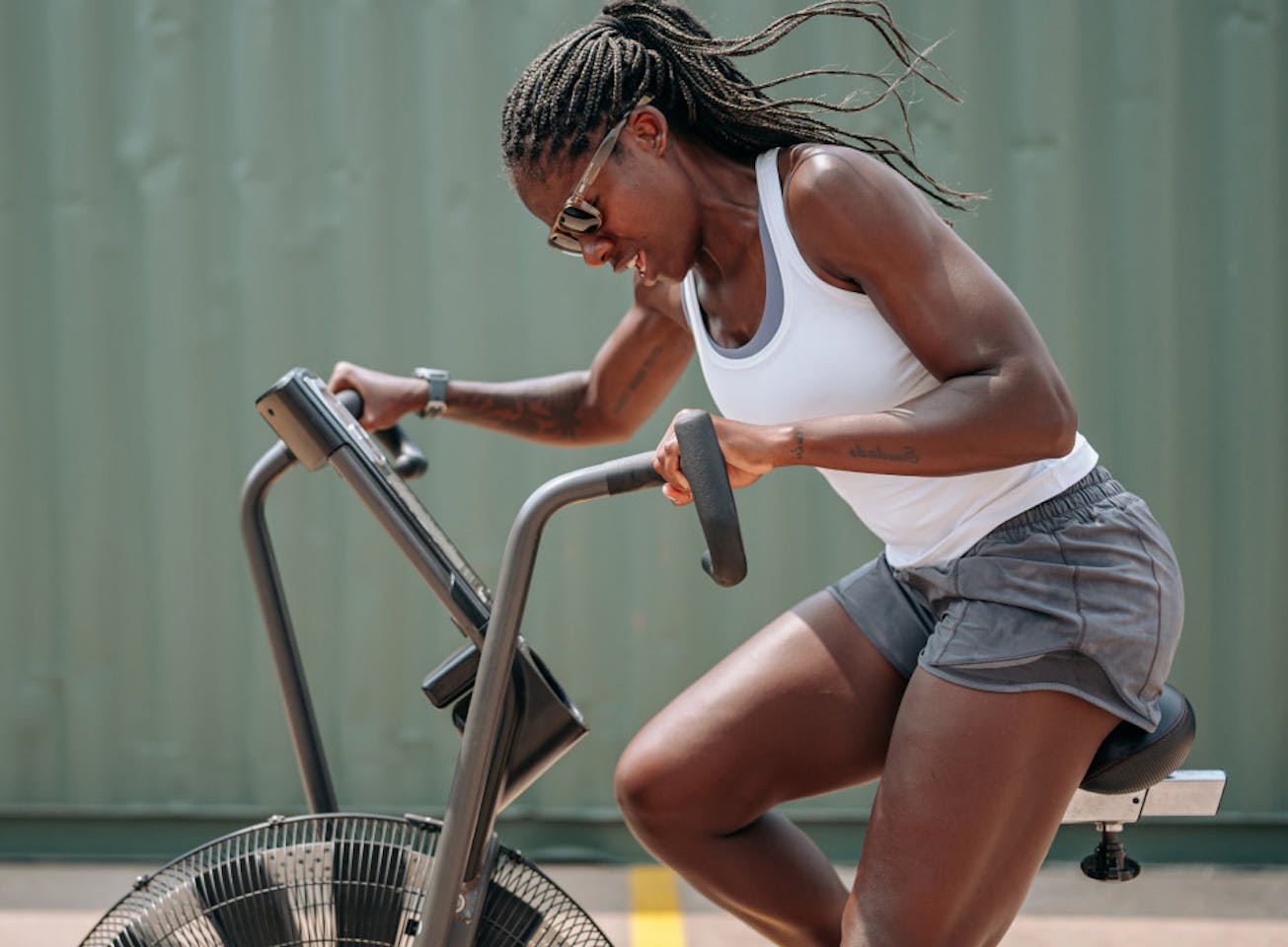 Woman riding air bike wearing Estacado sunglasses