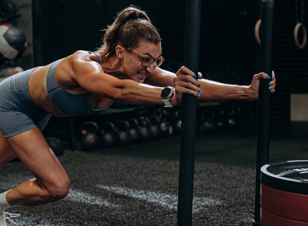 Woman pushing sled wearing Estacado sunglasses
