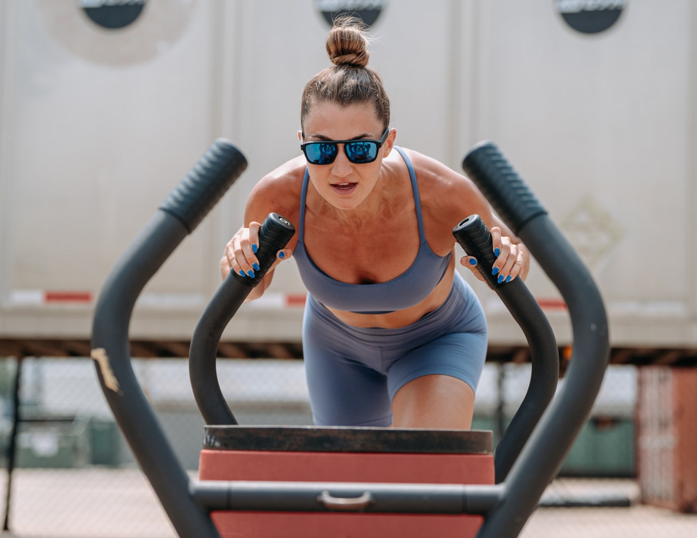 Woman pushing sled wearing Estacado sunglasses