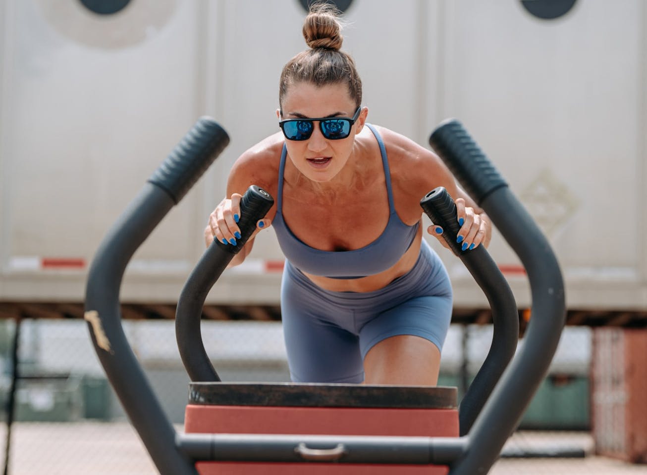 Woman pushing sled wearing Estacado sunglasses