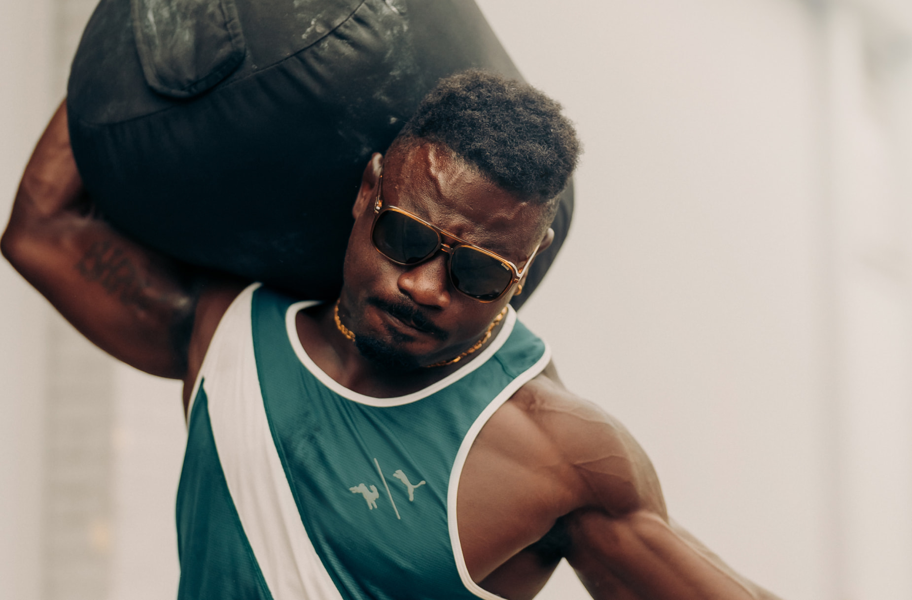 Man carrying medicine ball wearing Bandera sunglasses