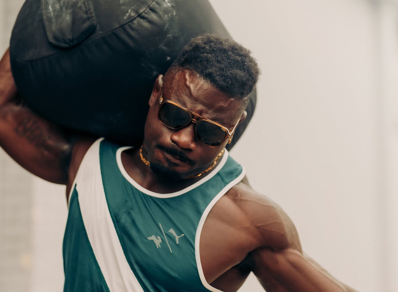 Man carrying medicine ball wearing Bandera sunglasses