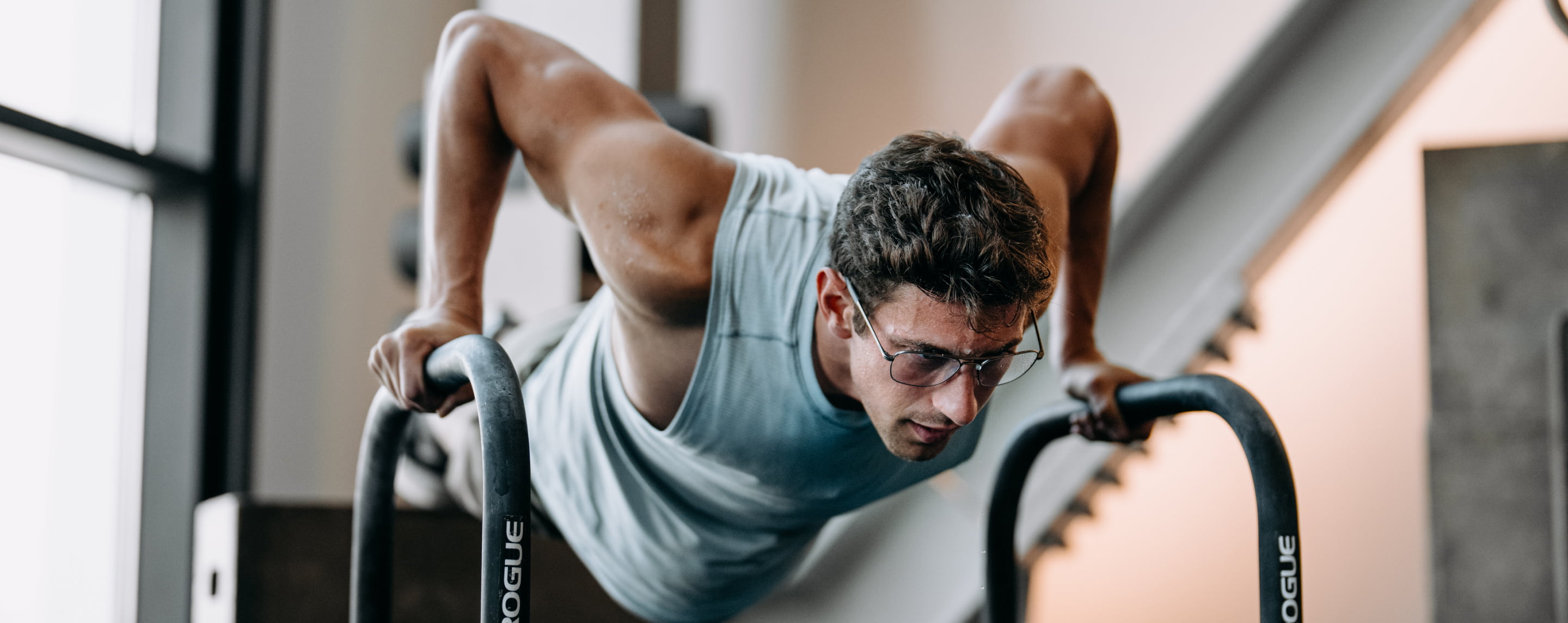 Man exercising in gym looking down wearing Falcon Titanium eyeglasses