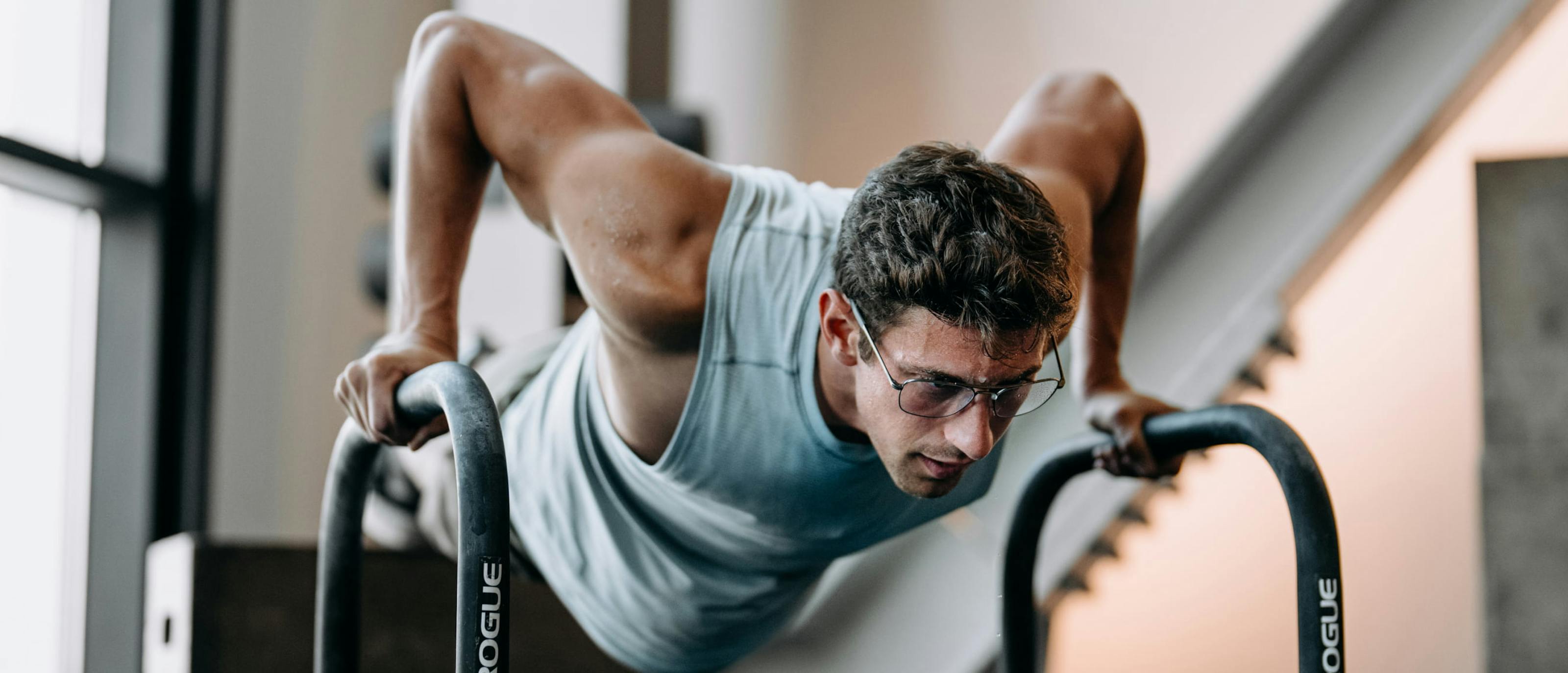Man exercising in gym looking down wearing Falcon Titanium eyeglasses