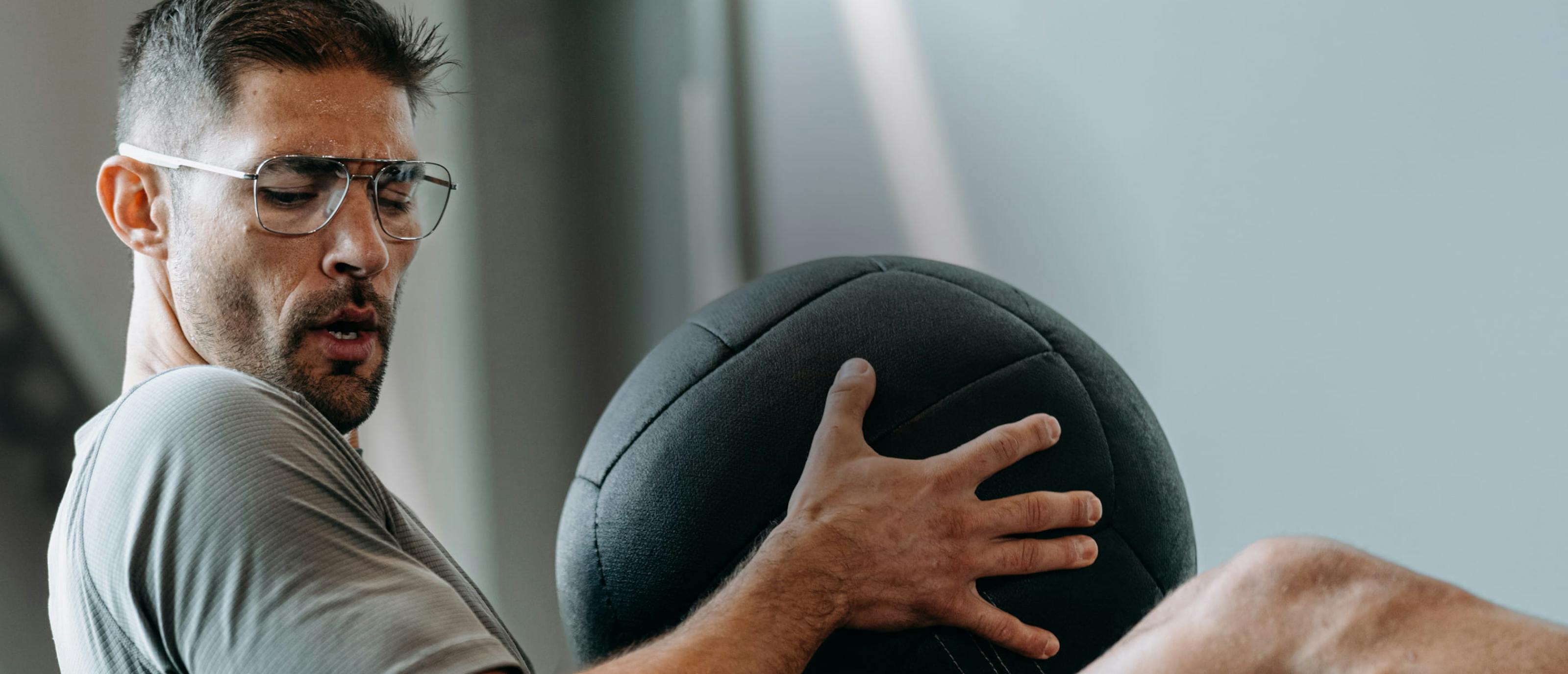Man using medicine ball wearing Falcon Titanium eyeglasses